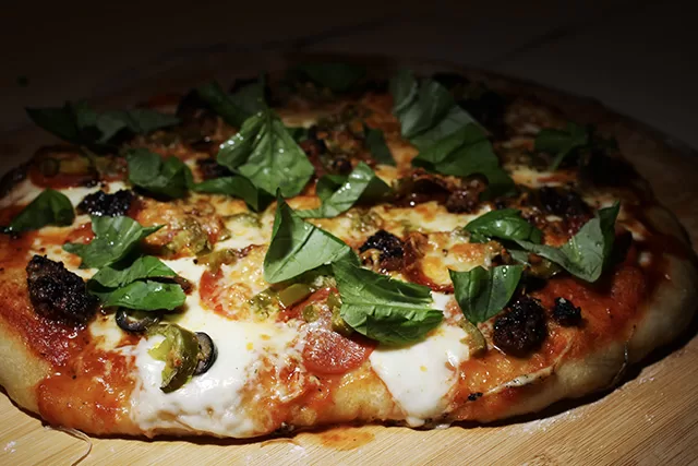 our signature homemade pizza topped with basil